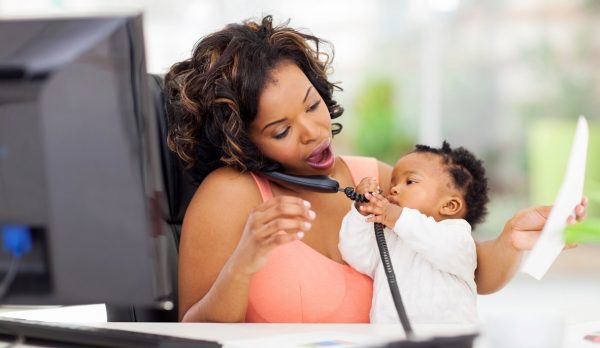 busy african businesswoman with baby girl working
